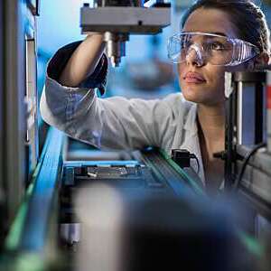 Quality control worker analyzing machine part on a manufacturing machine