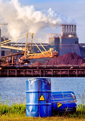 Two chemical waste drums, in front of a factory.