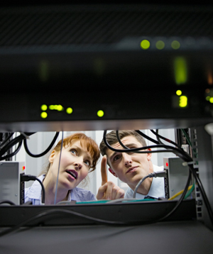 Two technicians talking and looking at a server.