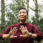 Senior woman doing Tai Chi outdoors.