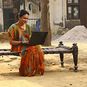Indian Happy rural women working on laptop in village. she is working with confidence